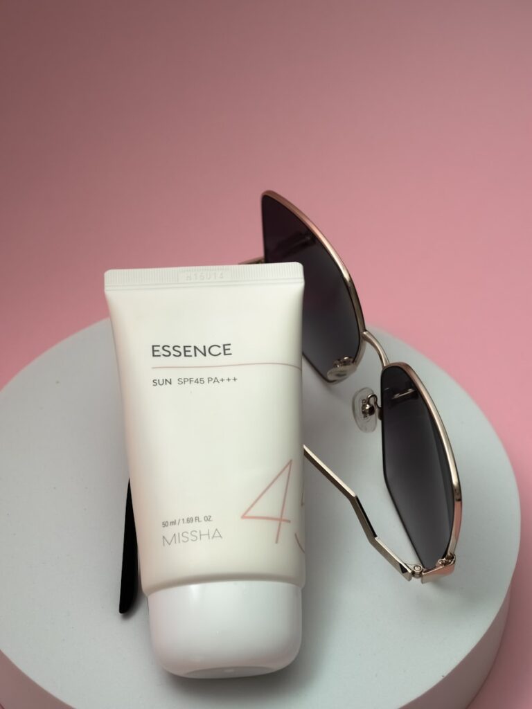 a pair of sunglasses, a tube of sunscreen and a tube of sunscreen