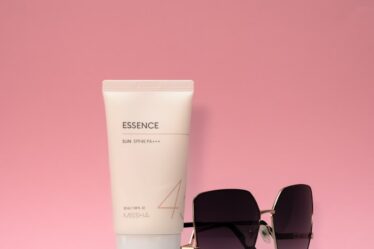 a pair of sunglasses, a tube of sunscreen and a tube of sunscreen