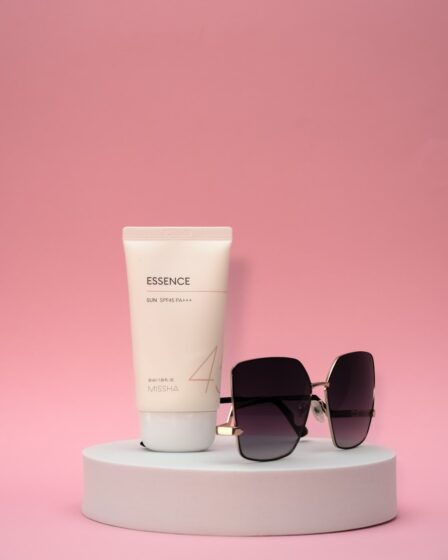 a pair of sunglasses, a tube of sunscreen and a tube of sunscreen