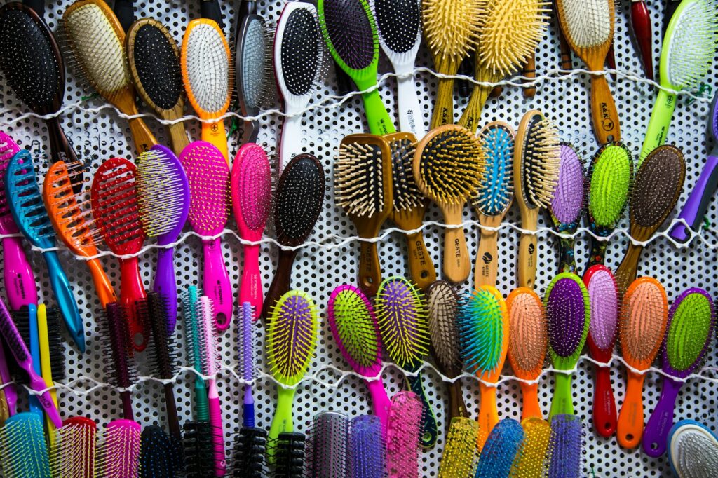a bunch of different colored brushes hanging on a wall