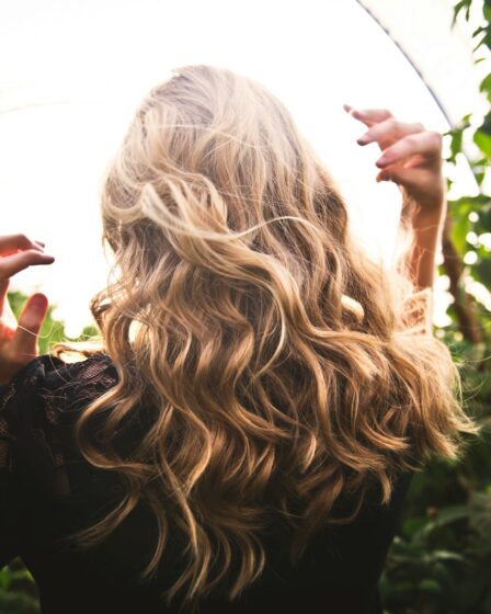blonde haired woman in black top surrounded by tall plants